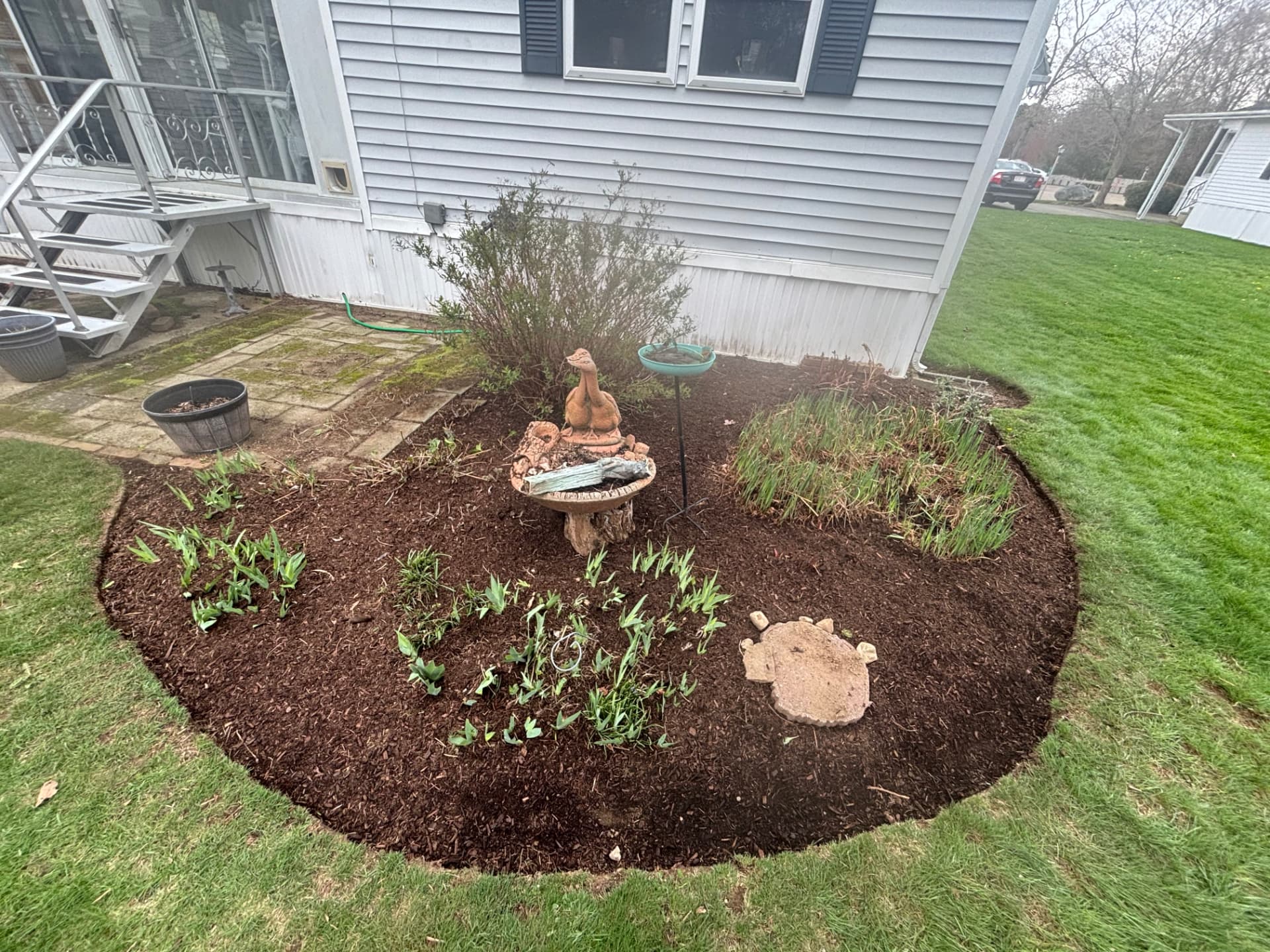 Freshly mulched garden bed beside a home