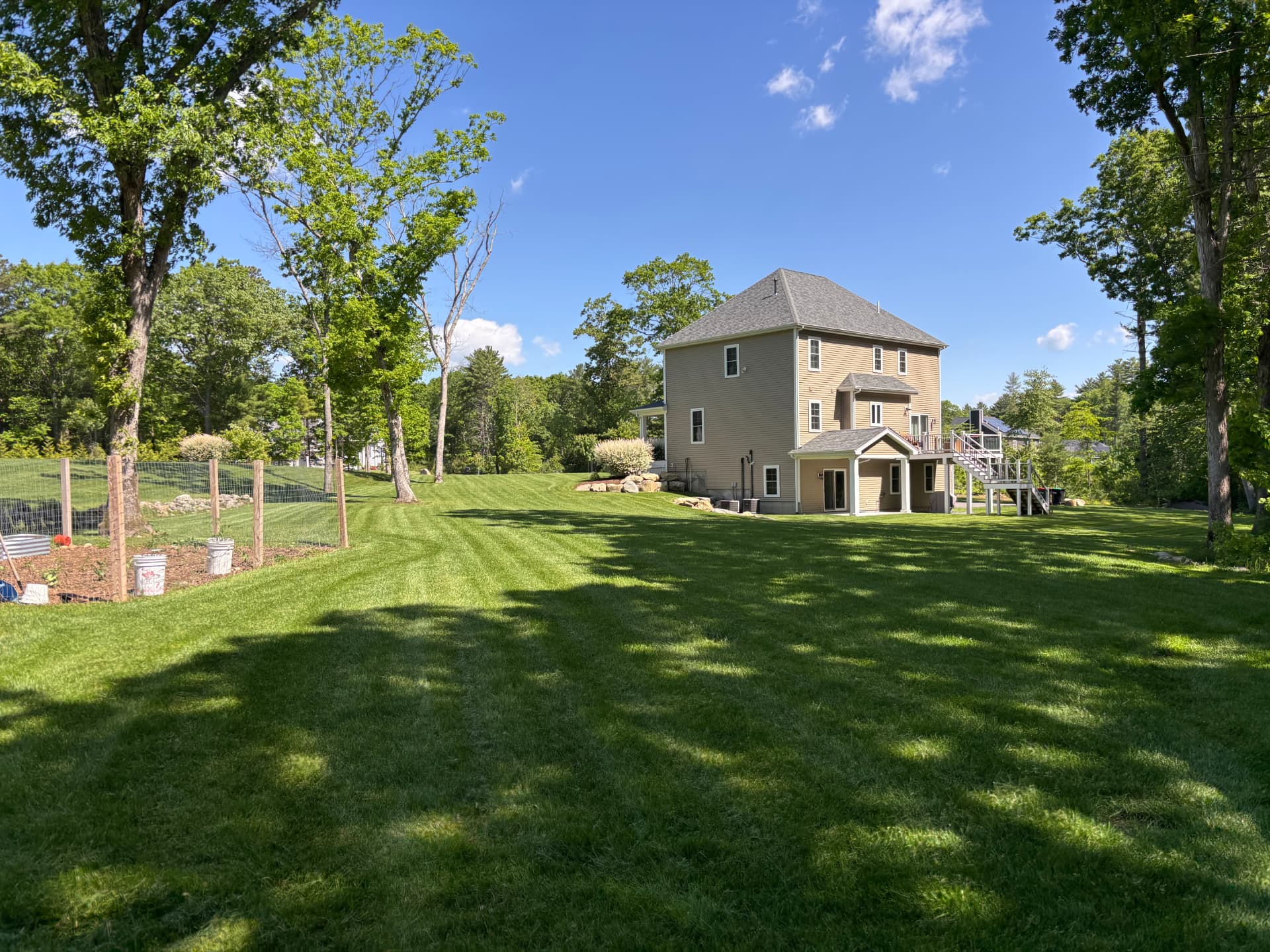 Large mowed backyard with tree line