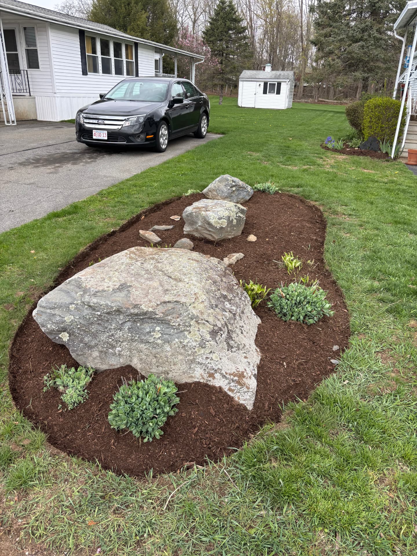 Boulder accent bed with fresh mulch and plantings